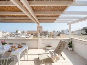a patio with a table and chairs on a roof at Terrazza San Martino Private Terrace Stay in Monopoli