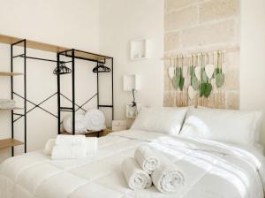 a bedroom with a white bed with towels on it at Terrazza San Martino Private Terrace Stay in Monopoli