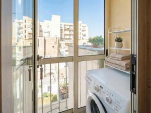 a washing machine in a room with a window at Terrazza San Martino Private Terrace Stay in Monopoli
