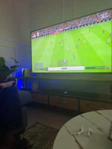 a large television screen with a soccer game on it at Demmys Comfort in Cape Town