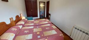 a bedroom with a bed with a purple comforter at Apartamentos Rurales Pernús in Colunga