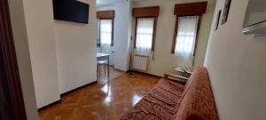 a living room with a chair and a television at Apartamentos Rurales Pernús in Colunga