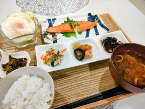 a table with plates of food and a bowl of rice at Villa FUN Kawana in Ito