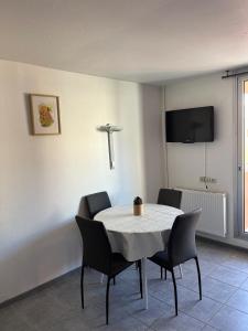 a dining room with a white table and chairs at Appartement Cap D'Agde in Cap d'Agde