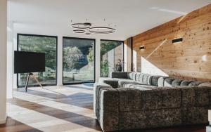 a living room with couches and a flat screen tv at Black Forest Deluxe in Hinterzarten