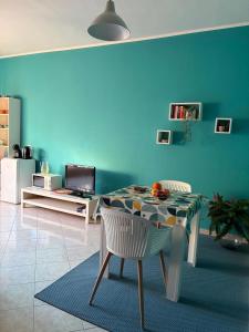 ein Esszimmer mit einem Tisch und einer blauen Wand in der Unterkunft Ca' Susy in Samone