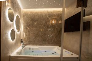 a bath tub in a bathroom with a stone wall at Elysium suites & Spa in Barletta