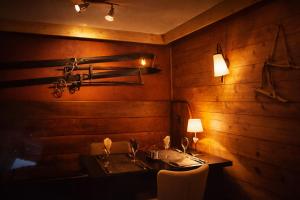 a dining room with a table and a lamp at Hôtel Chalet Alpage in La Clusaz