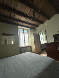 a bedroom with a large bed and two windows at Casa La Torretta in Ceva