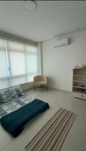 a bedroom with a bed and a chair in it at Solua Hostel in Santos +4 photos