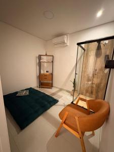 a room with a bed and a chair in it at Solua Hostel in Santos