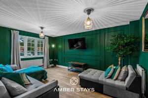 a living room with green walls and a couch at Spacious 5 Bed House in Reading by Amber Stays, Perfect for Business & Contractors, Sleeps 12 in Reading