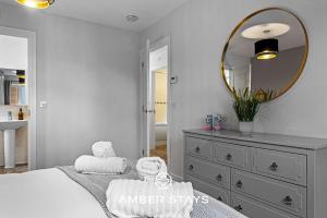 a bedroom with a bed with a mirror and a dresser at Spacious 5 Bed House in Reading by Amber Stays, Perfect for Business & Contractors, Sleeps 12 in Reading +40 photos