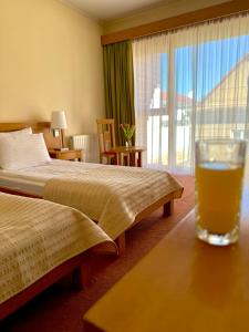 a glass of beer sitting on a table in a hotel room at Hotel - Restaurant Gonduzo in Odorheiu Secuiesc