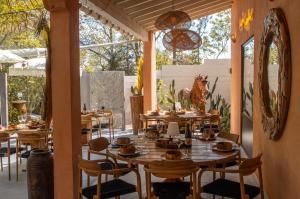 a restaurant with wooden tables and chairs on a patio at Camping la Peiriere - Évasion en Dôme in Tuchan