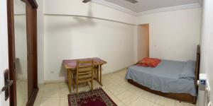 a small bedroom with a table and a bed at Light Tower in Alexandria