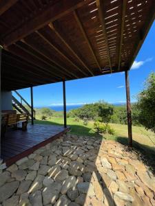 a patio with a roof with a view of the ocean at Wilderness Escape with breathtaking Views in Wildernis