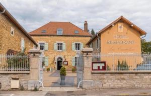 a building with a gate in front of a building at Hotel-restaurant Les Caudalies in Arbois