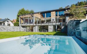 a house with a swimming pool in front of it at Black Forest Deluxe in Hinterzarten