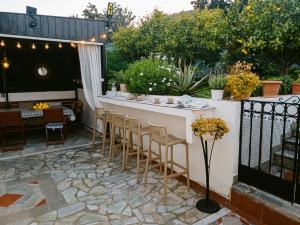 a patio with a bar with chairs and a table at Verdalia Private Holiday House in Stavrákia