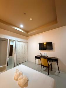 a bedroom with a desk and a bed and a table at Sierra Hotel in Dumaguete