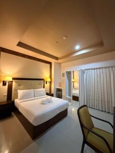 a bedroom with a bed and a chair in it at Sierra Hotel in Dumaguete +62 photos