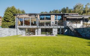 a large house with a large yard with green grass at Black Forest Deluxe in Hinterzarten