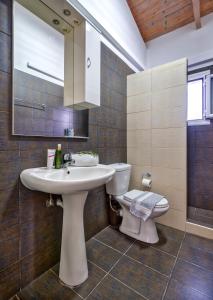 a bathroom with a white sink and a toilet at Schiza Houses in Finikounta