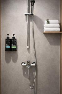a shower in a bathroom with two bottles of soap at Wink at Jalan Besar in Singapore
