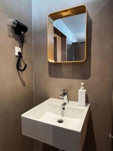 a bathroom with a white sink and a mirror at Wink at Jalan Besar in Singapore