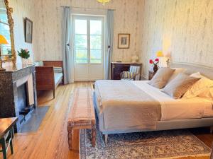 a bedroom with a large bed and a fireplace at Domaine de Montclair in Pommiers