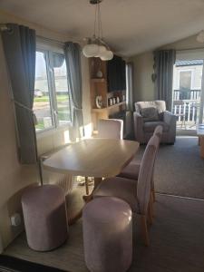 a living room with a table and chairs at Lapwing 26 in Scratby