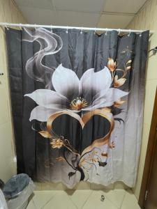 a shower curtain with a flower on it in a bathroom at Ajman Beach View AIO4OO7 in Ajman 