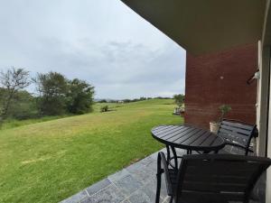 a table and chairs on a porch with a view of a field at Nestled sanctuary in Northriding
