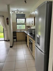 a large kitchen with a stainless steel refrigerator at Nestled sanctuary in Northriding
