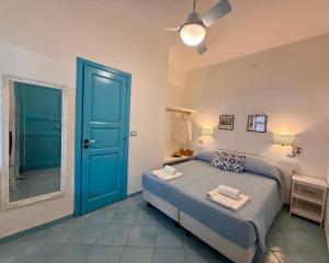 a bedroom with a bed and a blue door at La Giara in Vulcano