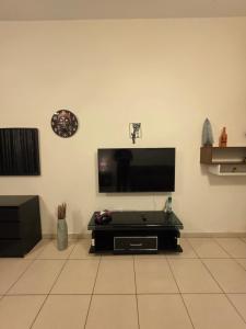 a living room with a flat screen tv on a wall at Ajman Beach View AIO4OO7 in Ajman  +11 photos