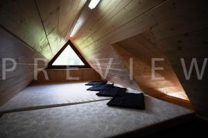 a attic room with a row of pillows on the floor at Ťatliakova chata in Zuberec