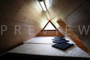 a small attic room with a bed with a window at Ťatliakova chata in Zuberec