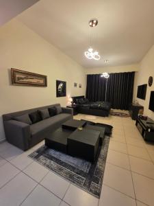 a living room with a couch and a table at Ajman Beach View AIO4OO7 in Ajman 