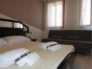 a bedroom with two beds and a couch at Rosario House in Comacchio +5 photos