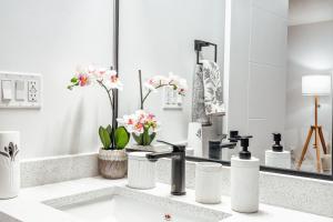 a white bathroom with a sink and a mirror at Executive Basement suite in Edmonton +18 photos