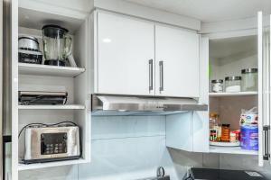 a kitchen with white cabinets and a microwave at Executive Basement suite in Edmonton