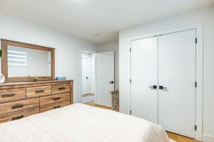 a bedroom with a bed and a dresser and a mirror at Executive Basement suite in Edmonton