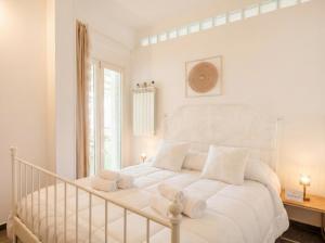 a white bedroom with a white bed with white pillows at CarmenLeo-Central Accommodation with Patio in Polignano a Mare
