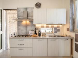 a kitchen with white cabinets and a sink at CarmenLeo-Central Accommodation with Patio in Polignano a Mare +13 photos