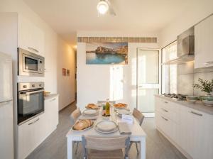 a kitchen with a table with plates of food on it at CarmenLeo-Central Accommodation with Patio in Polignano a Mare
