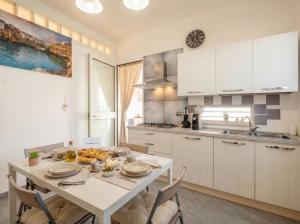 a kitchen with a white table and chairs in a room at CarmenLeo-Central Accommodation with Patio in Polignano a Mare