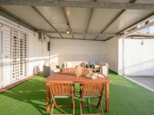 a table and chairs in a room with green grass at CarmenLeo-Central Accommodation with Patio in Polignano a Mare