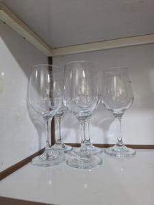 four wine glasses sitting on top of a table at Ajman Beach View AIO4OO7 in Ajman 